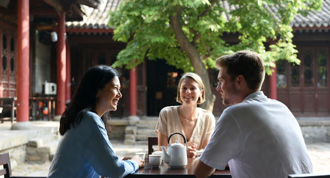Bildungsurlaub China mit LISA! – Chinesisch lernen, Kultur und authentische Erlebnisse Erwachsene im Gespräch in traditionellem Innenhof in China während eines LISA! Bildungsurlaubs lernen Chinesisch und erleben Kultur