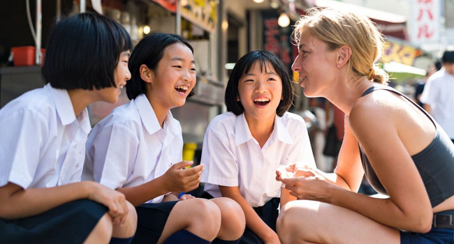 Bildungsurlaub Osaka Japan mit LISA! – Japanisch lernen, Kultur erleben und internationale Begegnungen Erwachsene im Gespräch mit japanischen Schülerinnen während eines LISA! Bildungsurlaubs erleben Kultur und lernen Japanisch in Osaka