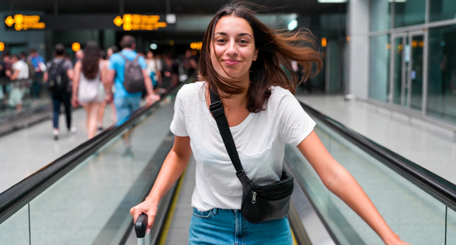  Junge Frau mit Koffer am Flughafen während einer LISA! Sprachreise freut sich auf die Anreise