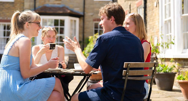 Erwachsene Teilnehmer im Café in Bournemouth während einer LISA! Sprachreise in England genießen eine Pause