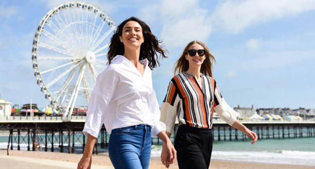 Zwei Teilnehmerinnen auf der Promenade in Bournemouth mit Riesenrad während einer LISA! Sprachreise in England