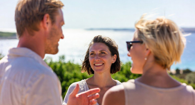 Erwachsene im Gespräch am Meer auf Malta während eines LISA! Bildungsurlaubs genießen internationale Atmosphäre und lernen Englisch