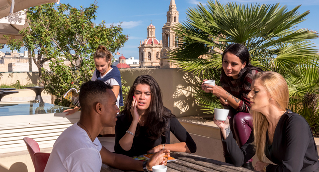 Teilnehmer einer Erwachsenen-Sprachreise in Malta auf der Dachterrasse der Sprachschule in Sliema mit Stadtblick