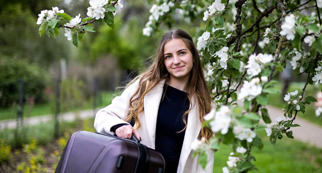 Mädchen mit Koffer unter einheimischen Apfelbaum symbolisiert die Buchung einer LISA! Sprachreise