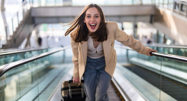 Bildungsurlaub Québec Kanada mit LISA! – Französisch lernen und entspannt anreisen Junge Erwachsene mit Koffer am Flughafen während eines LISA! Bildungsurlaubs freut sich auf Sprachreise nach Québec