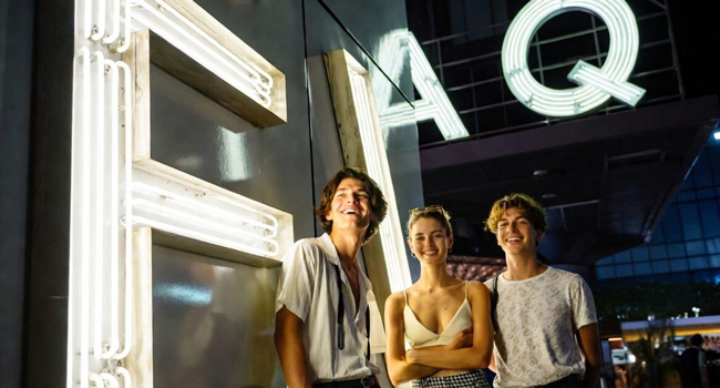Junge Erwachsene vor beleuchtetem FAQ Schild in Tokio während einer LISA! Sprachreise erleben das Nachtleben und die Stadt