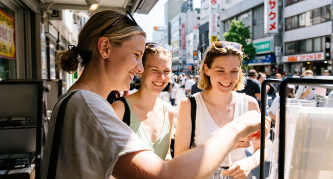  Erwachsene beim Street Food Einkauf in Tokio während einer LISA! Sprachreise entdecken lokale Spezialitäten und Kultur