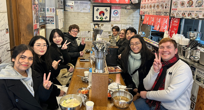  Erwachsene essen gemeinsam im Restaurant in Seoul während einer LISA! Sprachreise und genießen koreanische Küche in der Gruppe