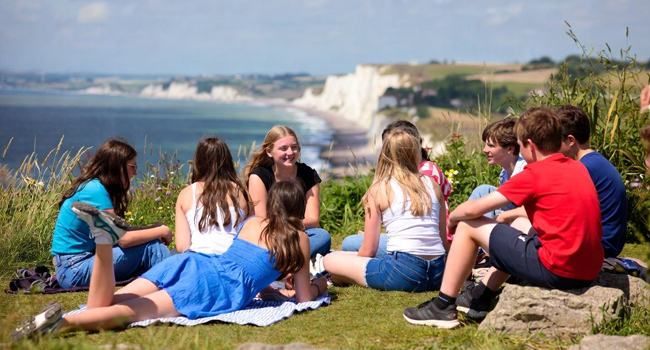 Schülergruppe in Eastbourne England während einer LISA! Sprachreise sitzt auf den Klippen mit Blick aufs Meer