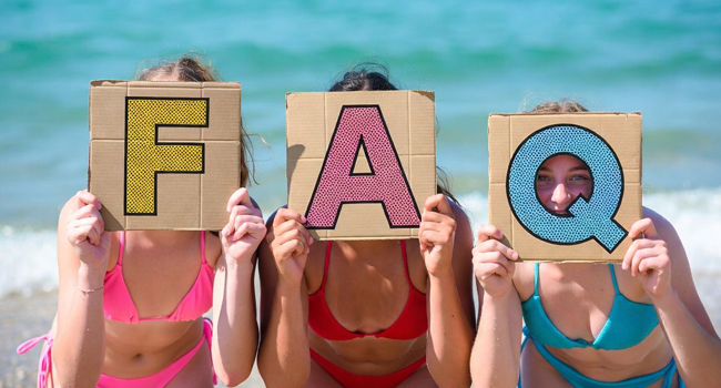 Drei Schülerinnen am Strand in Bournemouth Park England halten FAQ Schilder während einer LISA! Sprachreise