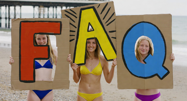 Drei Schülerinnen am Strand in Brighton halten große FAQ-Buchstaben während einer LISA! Schülersprachreise in England