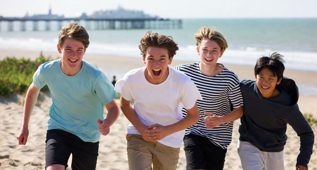  Vier Schüler laufen am Strand in Brighton während einer LISA! Schülersprachreise in England