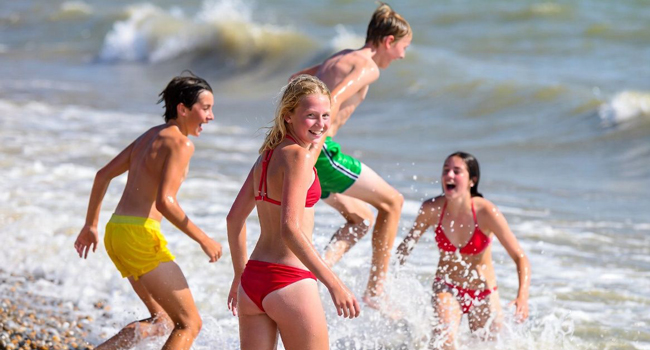  Schüler spielen im Meer während einer LISA! Schülersprachreise in England Brighton am Strand