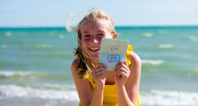  Schülerin am Strand in Exmouth während einer LISA! Sprachreise zeigt Einreisedokument ETA für England