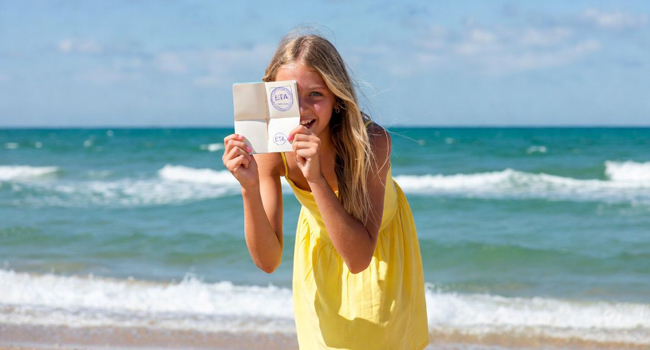 Schülerin am Strand in Portsmouth während einer LISA! Sprachreise zeigt Einreisedokument für England