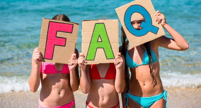 Schülerinnen am Strand in Portsmouth halten FAQ Buchstaben während einer LISA! Sprachreise mit Meer im Hintergrund