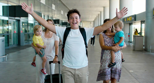 Schüler kommt am Flughafen mit erhobenen Armen an und freut sich auf seine LISA! Schülersprachreise