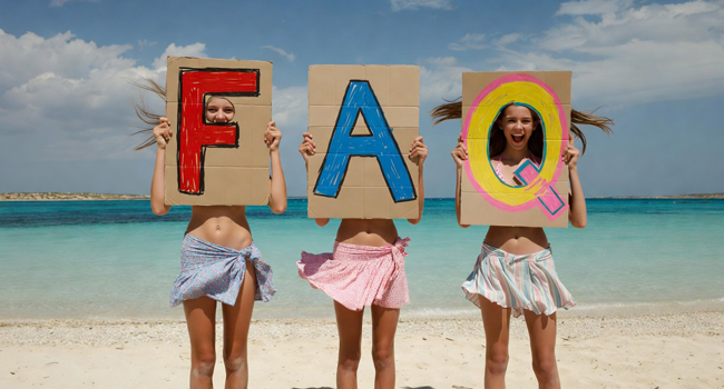 Drei Schülerinnen einer Schüler-Sprachreise in Malta am Salina Beach mit großen FAQ-Buchstaben vor dem Meer