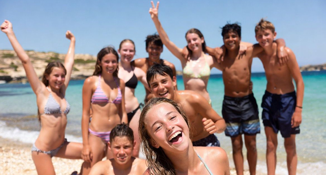 10 Teenager am Strand Malta San Gwann beim Freizeitprogramm erhobene Arme