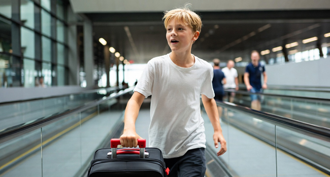 Junge reist im Flughafen auf Laufband an zu einer Sprachreise für Schüler in Málaga