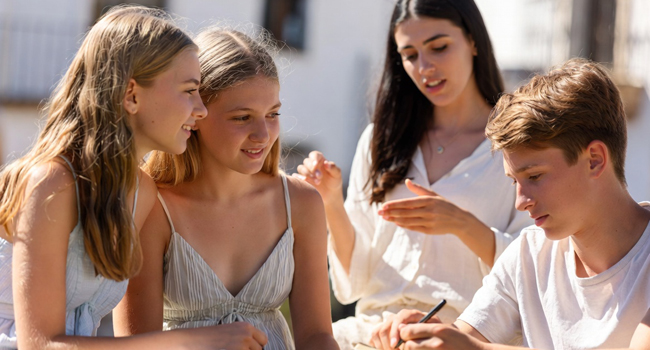 Drei blonde Kinder lernen gemeinsam Deutsch