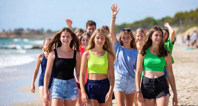 Young Adults am Strand in Mallorca während einer LISA! Sprachreise spazieren gemeinsam am Meer entlang und genießen die Freizeit