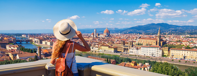 Traumstadt mit Dom und Kirchen - bei einer Italienisch-Sprachreise mit Bildungsurlaub erleben Eine blonde Frau mit Sonnenhut blickt vom Piazza Michelangelo auf die Stadt Florenz
