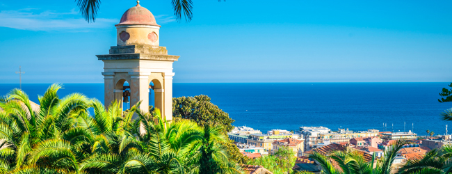 Bildungsurlaub Italien mit blauem Meer und Palmen in Sanremo Blick zum blauen Meer mit Palmen und italienischem Kirchturm davor
