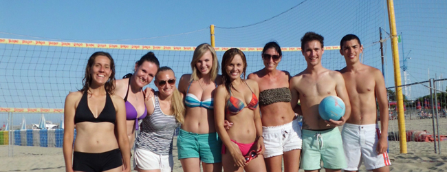 Beachvolleyball am Strand bei einem Bildungsurlaub am Meer in Sanremo Eine Gruppe von Sprachschülern stehen am Strand vor einem Beach Volleyballfeld
