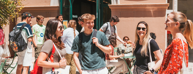 Sprachschüler stehen auf einem sonnigen Innenhof der Sprachschule in Barcelona