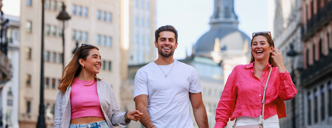 Drei Erwachsene spazieren durch die Strassen von Madrid