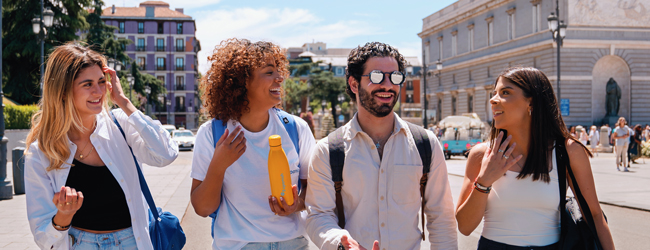 Vier Erwachsene unterhalten sich beim Bummel durch Madrid beim Bildungsurlaub