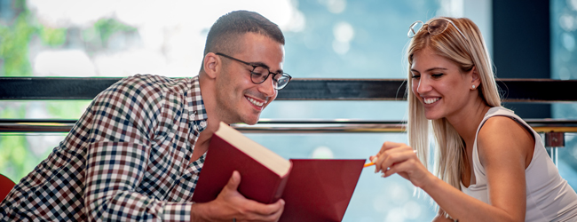 Ein Mann und eine Frau schauen in ein Buch bei einem Bildungsurlaub in Malaga