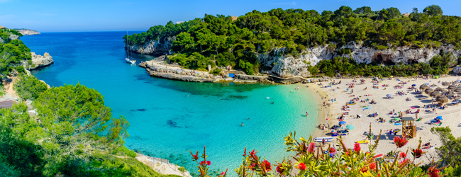 Bildungsurlaub Spanisch in Mallorca - Strand und Meer Blick in eine Bucht mit Strand uns türkisblauem Wasser auf Mallorca
