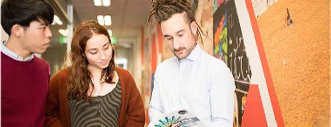 Gemeinsam lernen an der Sprachschule Englisch in Melbourne Drei junge Leute schauen gemeinsam in ein Buch beim Cambridge Certificate Vorbereitungskurs in Melbourne