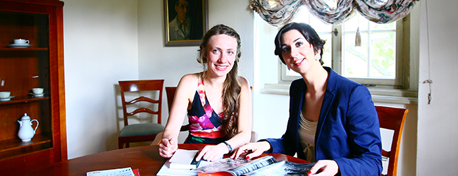 Zwei Frauen sitzen an einem Tisch und lernen gemeinsam