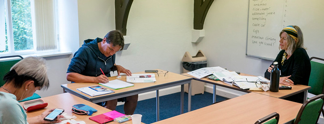 Zwei personen und eine Lehrerin beim Englisch-Unterricht an der Sprachschule in Jersey