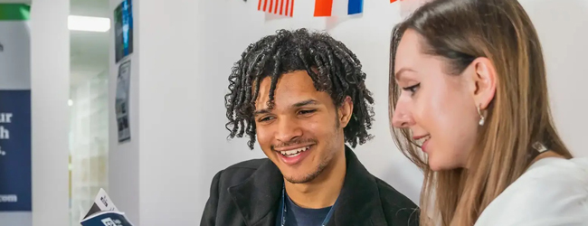 Englisch lernen gemeinsam mit Sprachkursen an der LISA! Sprachschule in Toronto Eine Frau und ein Mann betrachten eine Broschüre im Englisch-Unterricht an der Sprachschule in Toronto