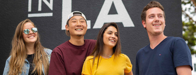 Vier junge Menschen strahlen in der Sonne kaliforniens bei einer Sprachreise nach Los Angeles