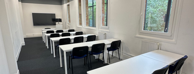 Leeres Klassenzimmer mit blauen Stühlen und Blick ins Grüne in der LISA! Sprachschule in Paris