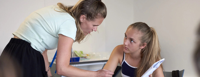 Lernsituation im Klassenzimmer bei einer LISA! Familiensprachreise Eine Lehrerein erklärt einer Schülerin etwas bei einem LISA! Sprachkurs in Brighton