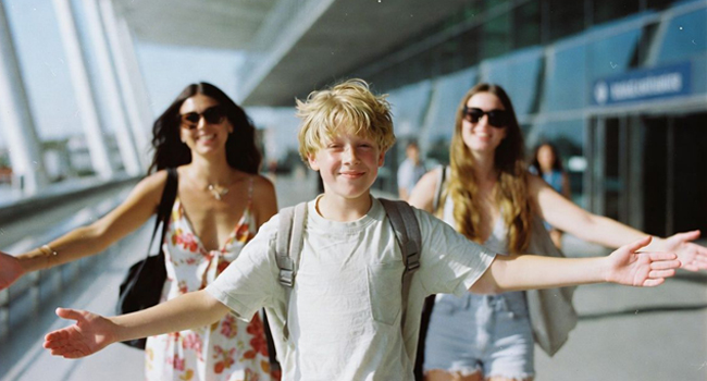 Ankunft Junge auf dem Flughafen Bangkok mit seiner Familie