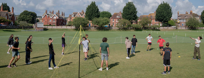 Volleyball spielen bei einer Sprachreise in Eastbourne für Schüler Kinder spielen auf einer Wiese Volleyball, im Hintergrund englische Häuser von Eastbourne
