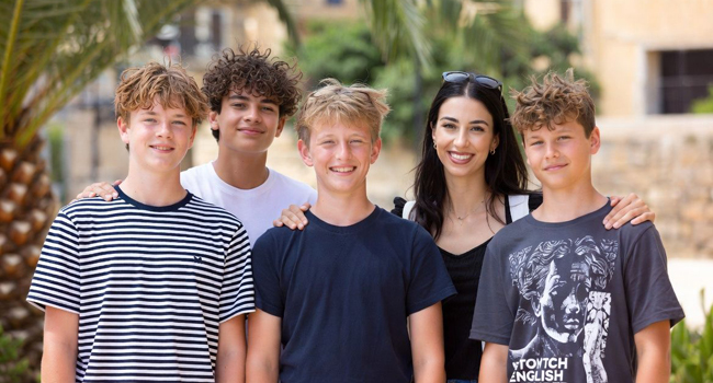 Betreuung während einer Sprachreisen für Schüler in Malta San Gwann Betreuerin und Lehrerin mit vier Buben vor Palme auf Sprachreisen Malta San Gwann