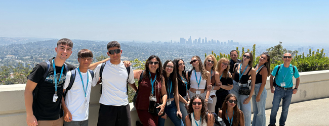 Hügel in Los Angeles vor blauem Himmel bei einer Sprachreise für Schüler Schüler stehen vor dem Panorama von Los Angeles mit Häusern in den Hügeln und blauem Himmel