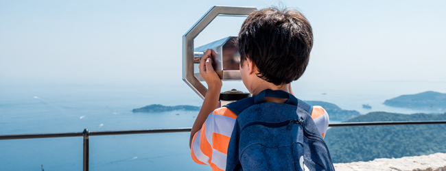 Meerblick mit Fernrohr bei einer LISA! Sprachreise für Schüler in Nizza-Campus Ein Junge schaut durch ein Fernrohr aufs Meer bei einer Sprachreise in Nizza-Campus