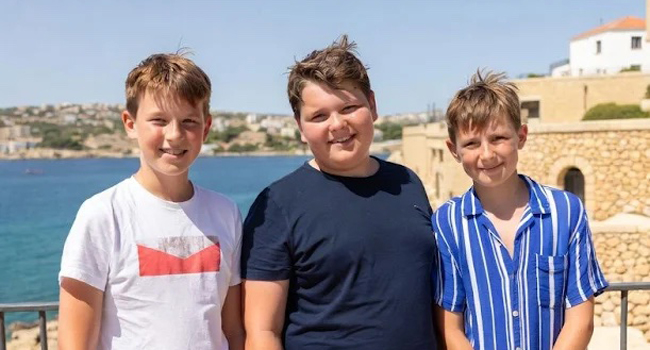 Drei Jungen stehen am Meer in Malta und genießen die Sonne bei einer Sprachreise